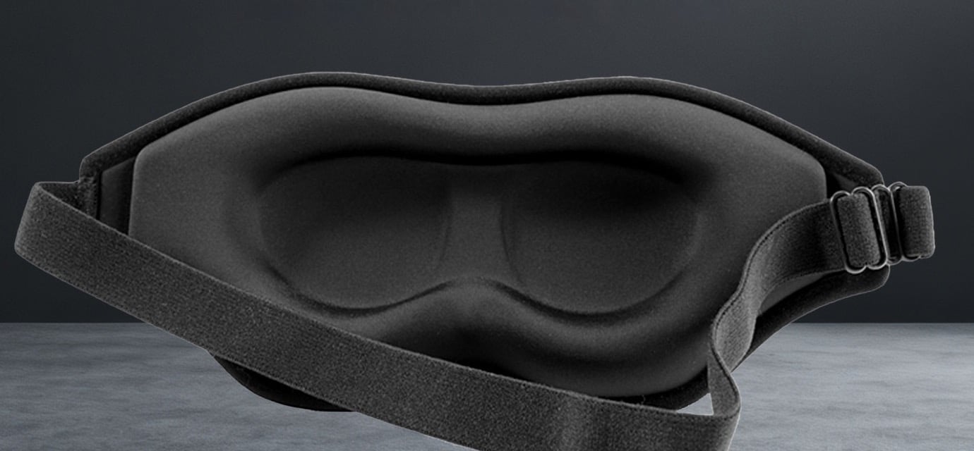 NightVeil weighted sleep mask with contoured eye cups and adjustable strap, on a dark surface