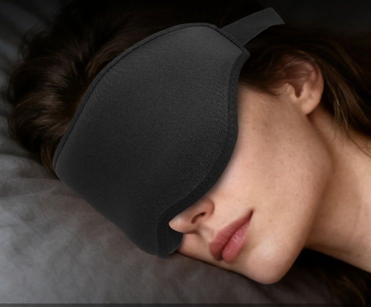 A woman sleeping deeply on her side wearing the NightVeil weighted sleep mask